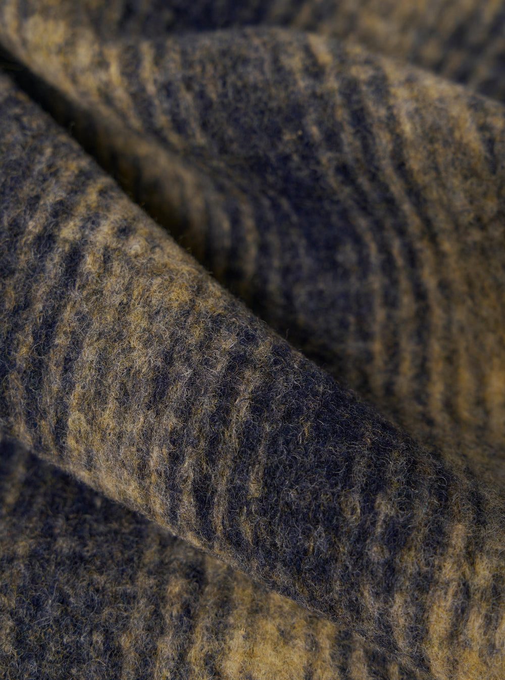 Close-up of the textured Navy Uist Fleece Zip Liner Jacket. The fabric shows a blend of navy and gold fibers. The image highlights the soft, plush texture of the fleece.