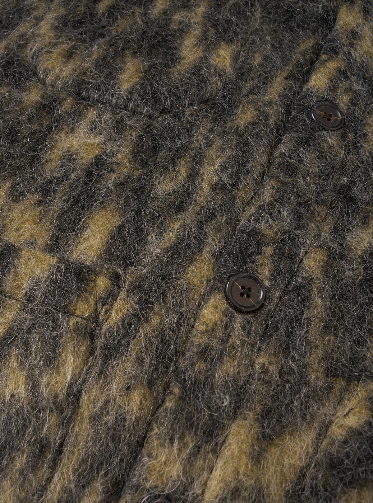 Detailed view of the Charcoal Dolce Fleece Cardigan worn by a model against a clean, light backdrop. The shot focuses on the intricate wool-mohair fabric weave, jersey-bound placket, tonal buttons, and neat pocket construction.