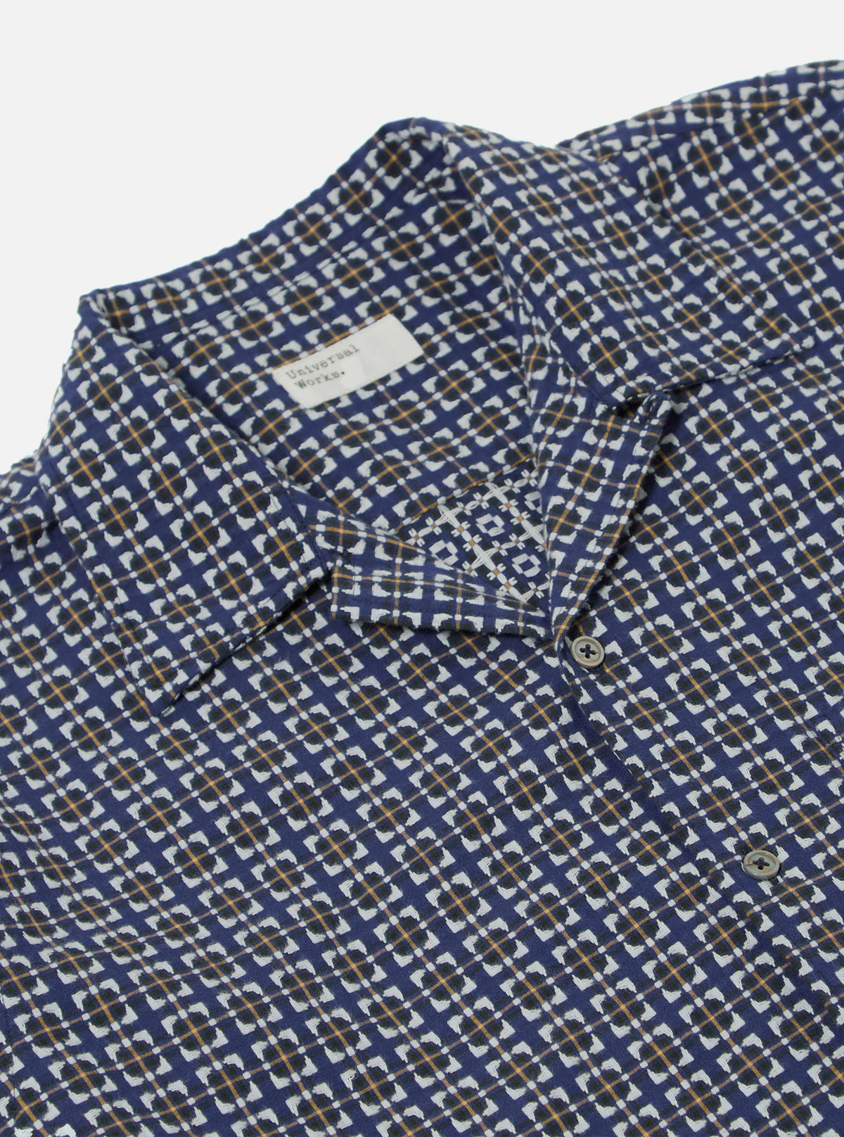 Close-up of the Navy Oscar Cotton L/S Camp Shirt on a white background. The shirt features a navy, white, and gold pattern. The fit is relaxed. 