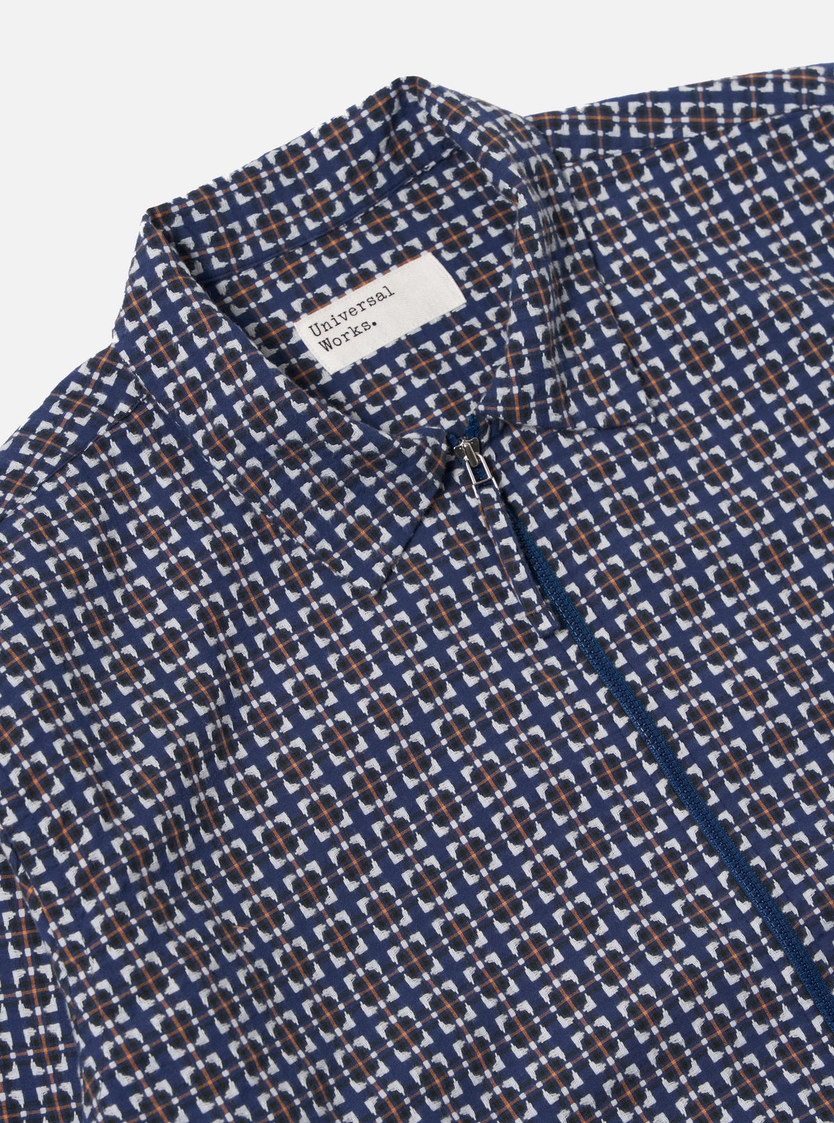 Close-up of the Navy Oscar Cotton Zip Shirt on a white background. The shirt has a navy, white, and orange pattern and a zip closure.