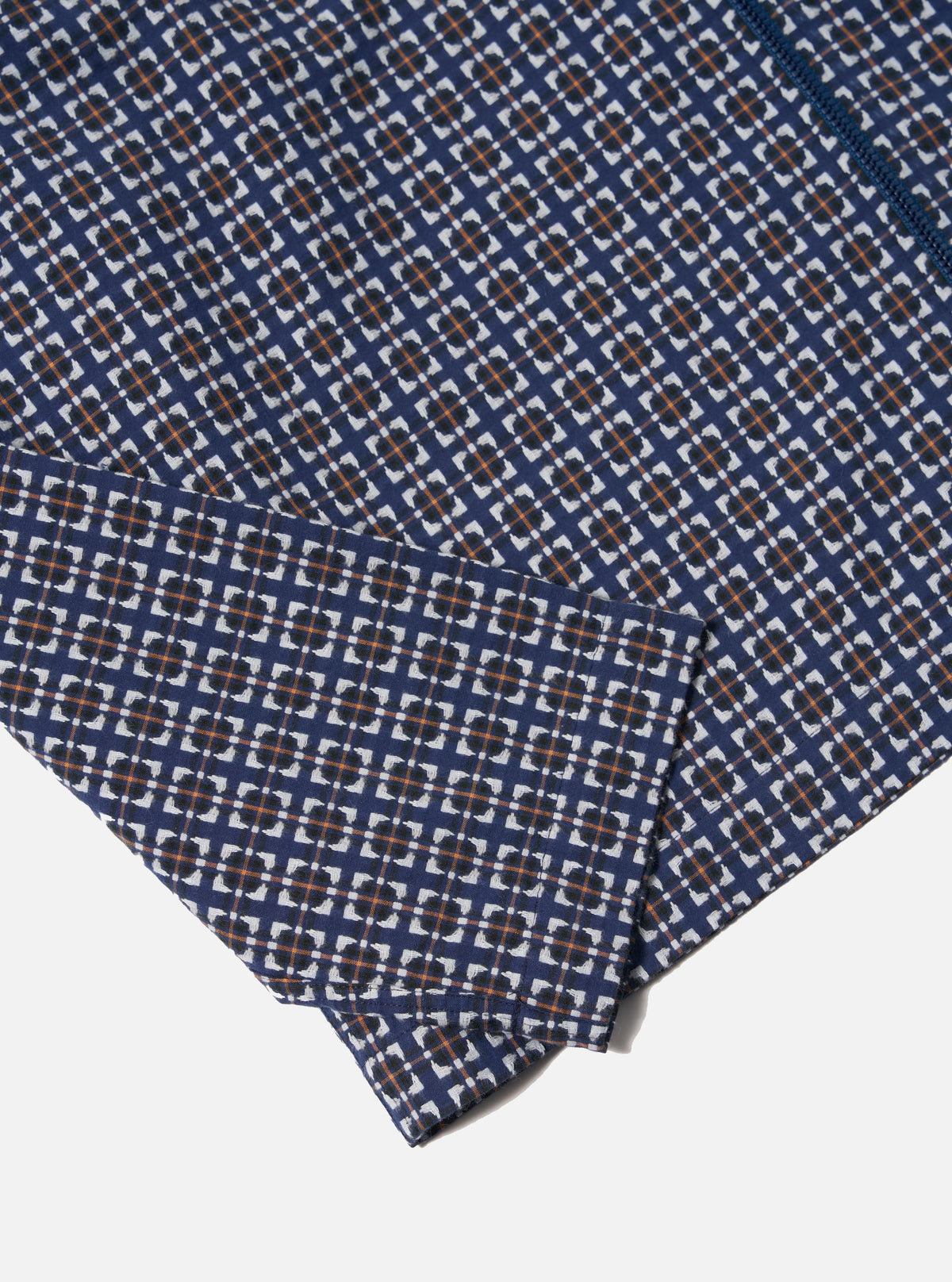 Close-up of the Navy Oscar Cotton Zip Shirt, showcasing its navy, white, and orange geometric pattern on a white background. The cotton fabric and zip detail are visible.