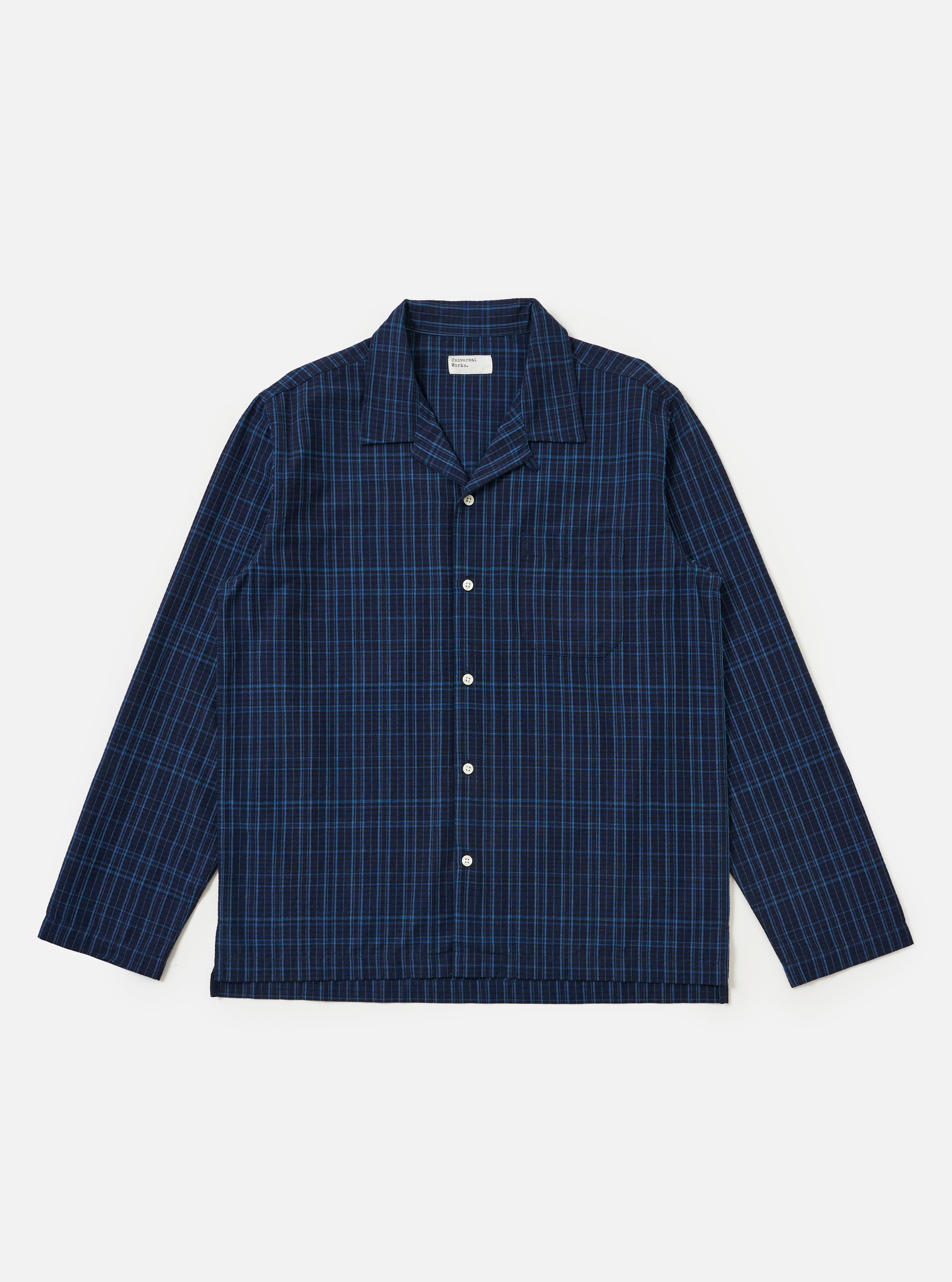 Flat lay of the Indigo Plaid Long Pyjama Set top on a white background. The top is blue plaid with long sleeves and white buttons.