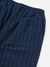 Close-up of the Indigo Plaid Long Pyjama Set. The blue plaid cotton pants have an elastic waist and a pocket. Shot on a white background.