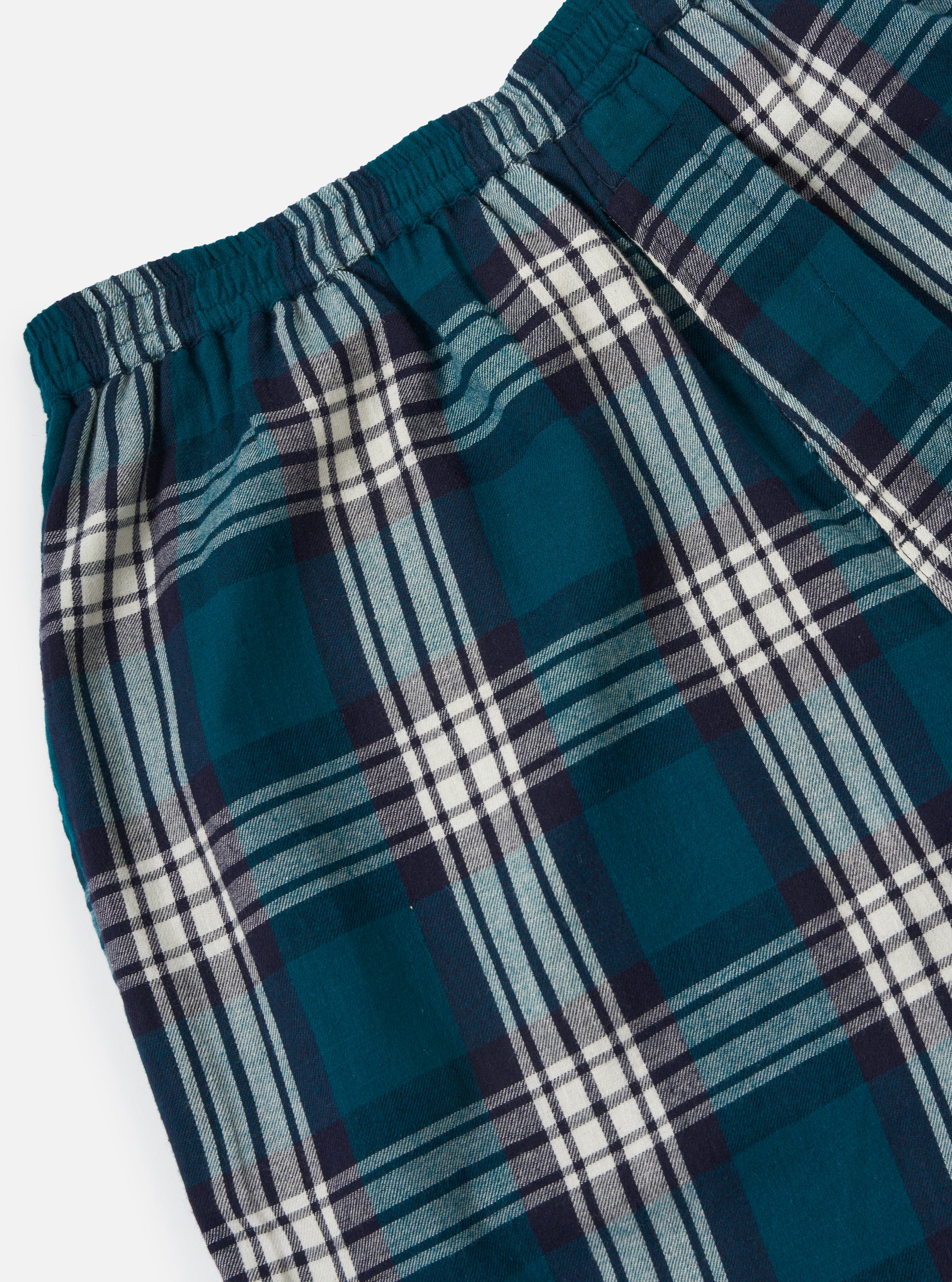Close-up of the Forest Brushed Plaid Pyjama Short. The shorts have a green, white, and navy plaid pattern and an elastic waistband. Shot on a white background.