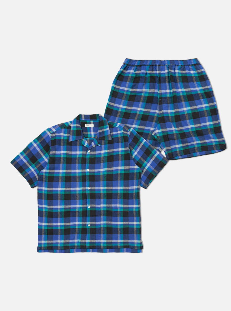 The Blue Night Check Short Pyjama Set on a white background. The set features a blue, black, and white check pattern. The top is a short-sleeved shirt, and the bottoms are shorts.