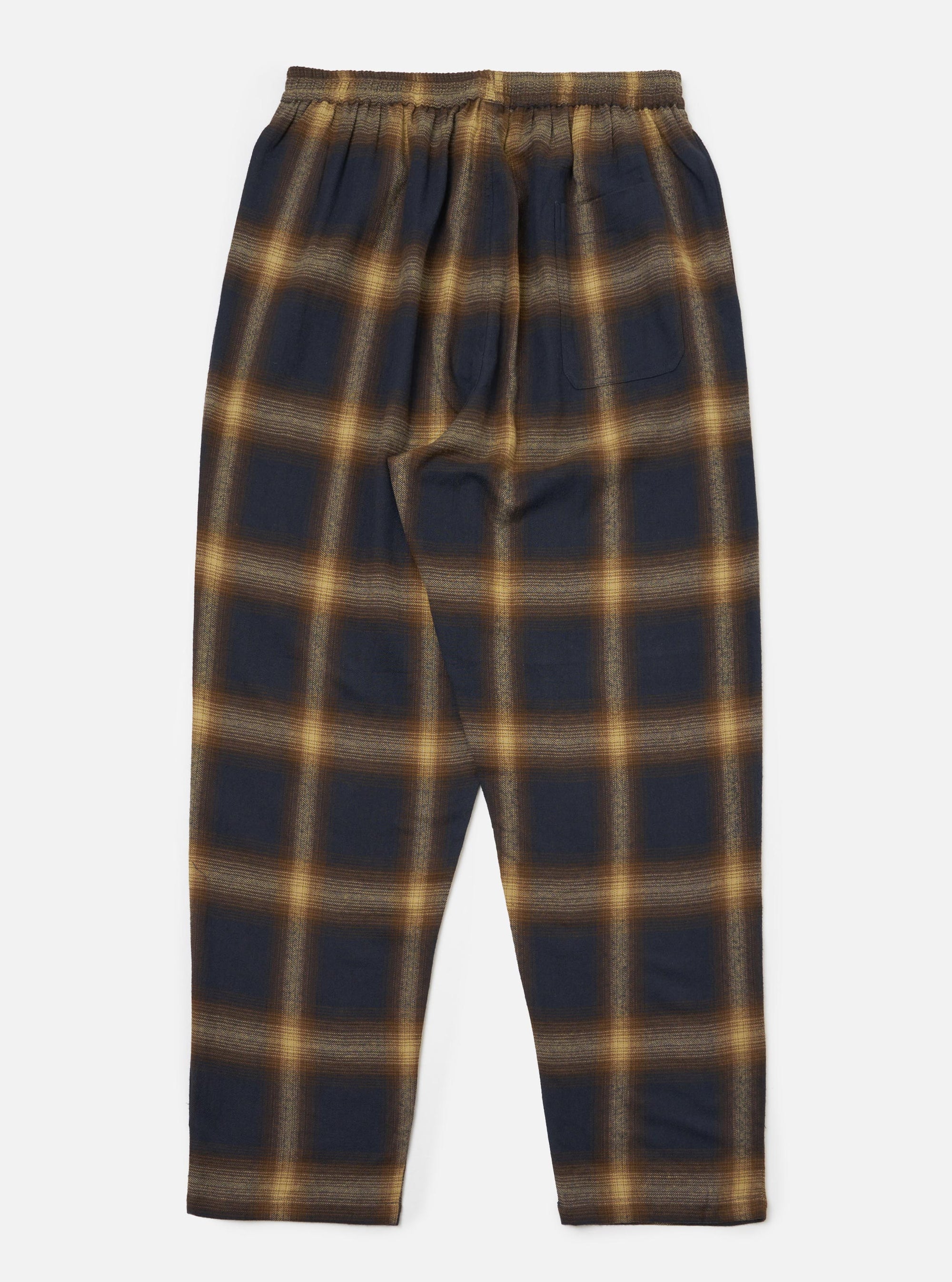 The Navy Canyon Check Pyjama Pant, laid flat on a white surface. The pants are a navy and tan plaid, with an elastic waistband.
