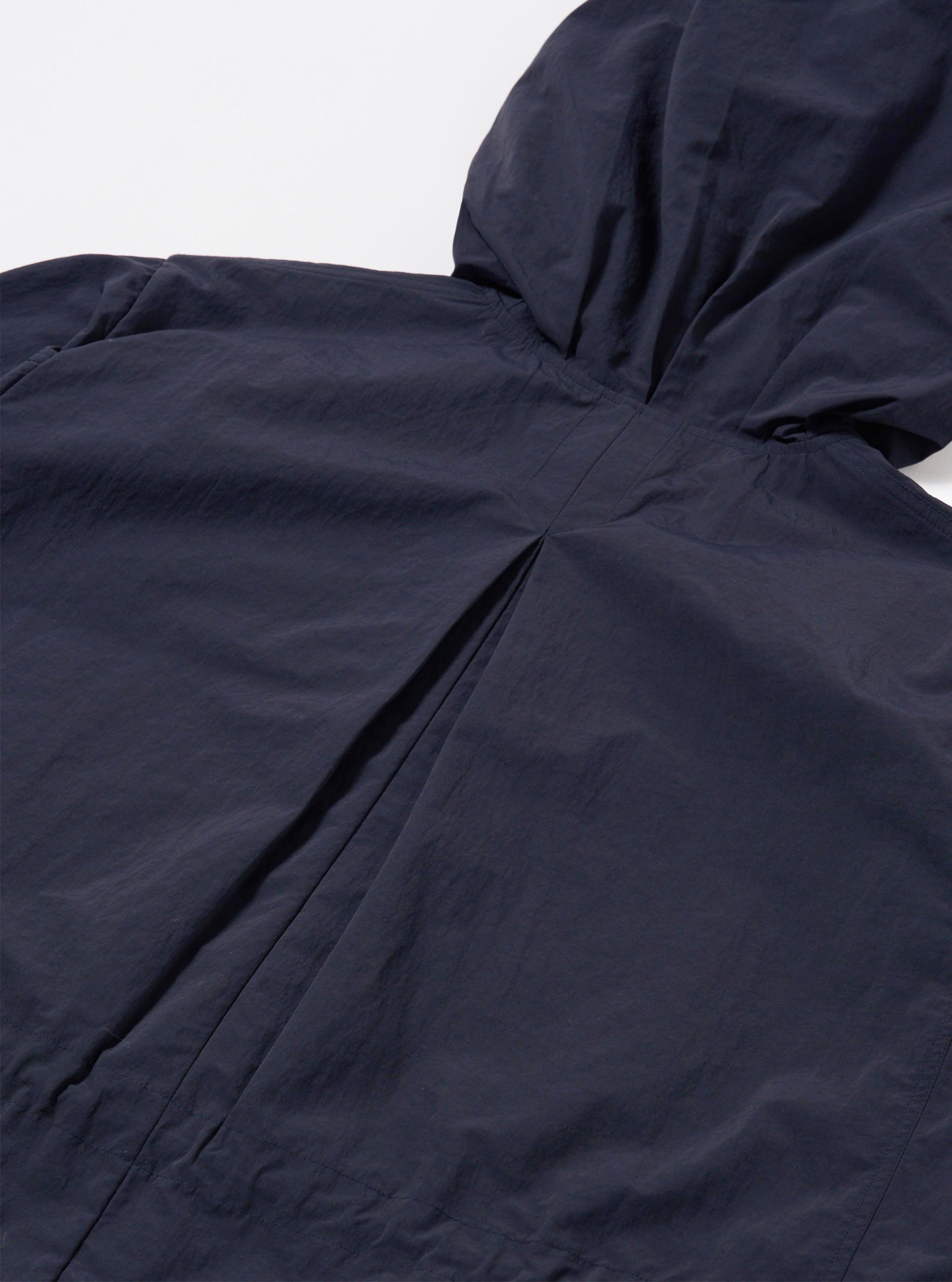 The Navy Seo Recycled Nylon Boston Parka is shown in a detail view as a flat lay against a plain white background. The image highlights the technical, smooth texture of the navy blue recycled nylon fabric and focuses on functional construction details such as the hood or a pocket.