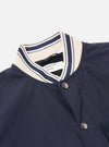 The Navy Peached Poplin NS Bomber Jacket is shown from the back as a flat lay against a plain white background. The image highlights the jacket's smooth navy cotton poplin fabric, a central vertical seam, and the contrast stripe ribbing on the collar, cuffs, and hem.