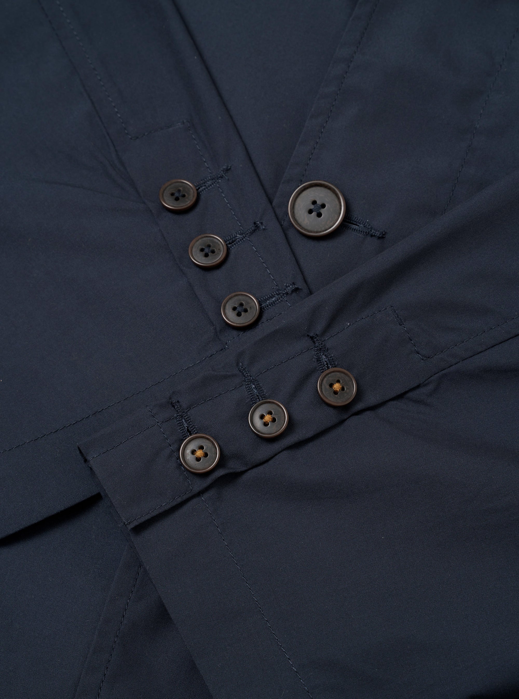 The Navy Recycled Polytech Capitol Jacket is shown from the back as a flat lay against a white background. This unstructured blazer features a single back vent, long sleeves with functioning button cuffs, and a notched lapel. The fabric has a smooth, matte navy blue finish.