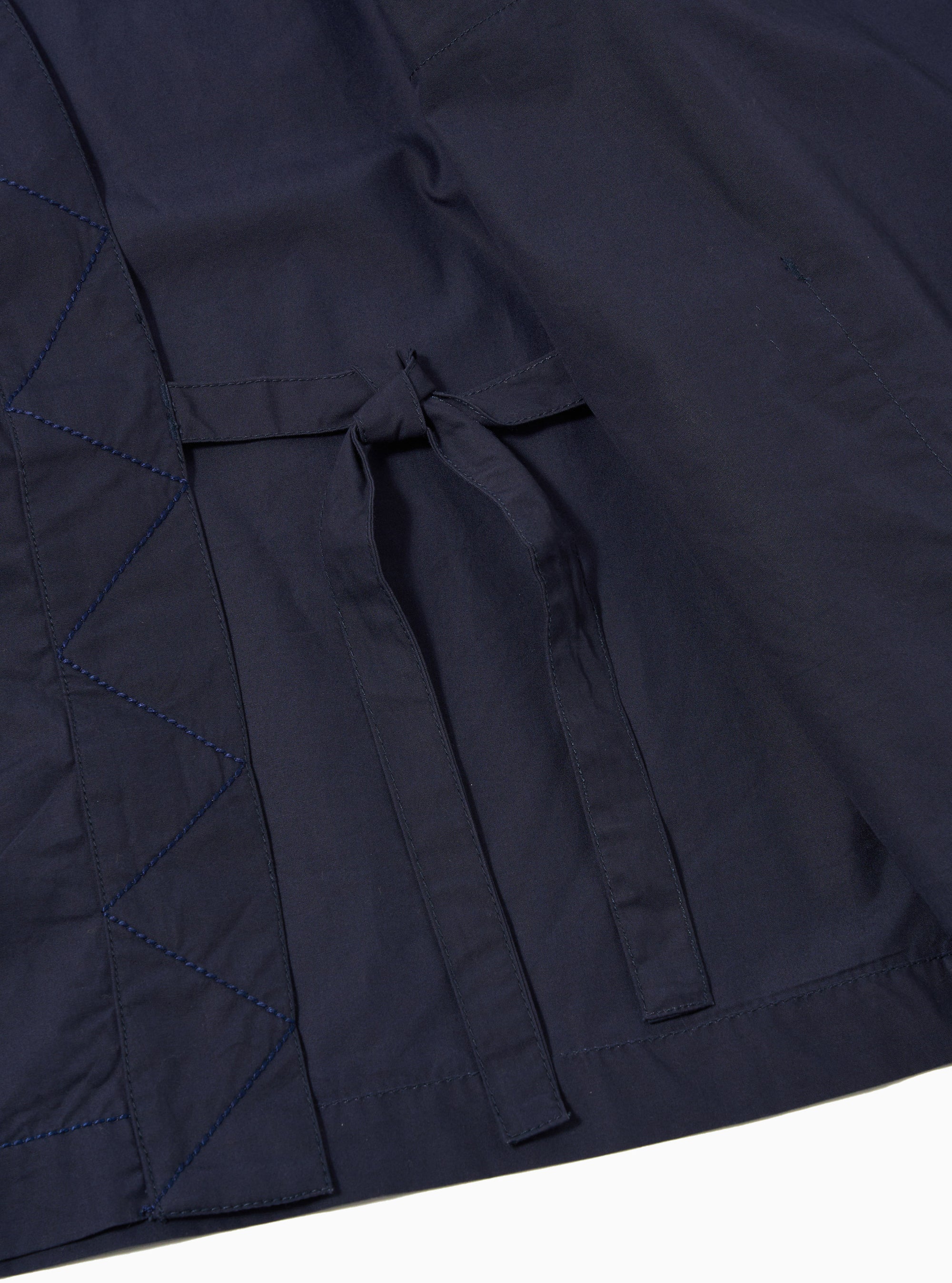 The Navy Peached Poplin Osaka Work Jacket is shown from the back as a flat lay against a plain white background. The image highlights the clean lines of the jacket's rear panel, the simple wrap-style collar, and the smooth, matte texture of the navy blue cotton poplin.