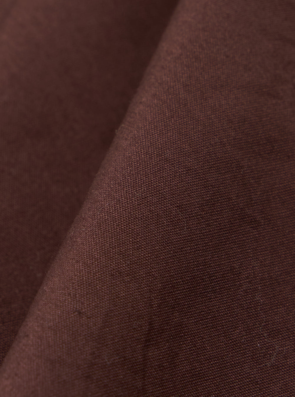 A close-up swatch image of the Brown Peached Poplin Osaka Work Jacket fabric displays a solid brown color with a soft, peached texture. The cotton poplin material fills the frame, highlighting the matte finish and fine weave.