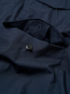 The Navy Recycled Polytech Parachute Field Jacket is shown from the back as a flat lay against a plain white background. The image highlights the jacket's smooth, dark navy fabric and its straight hem with an adjustable drawcord. A simple, horizontal yoke seam is visible across the upper back.