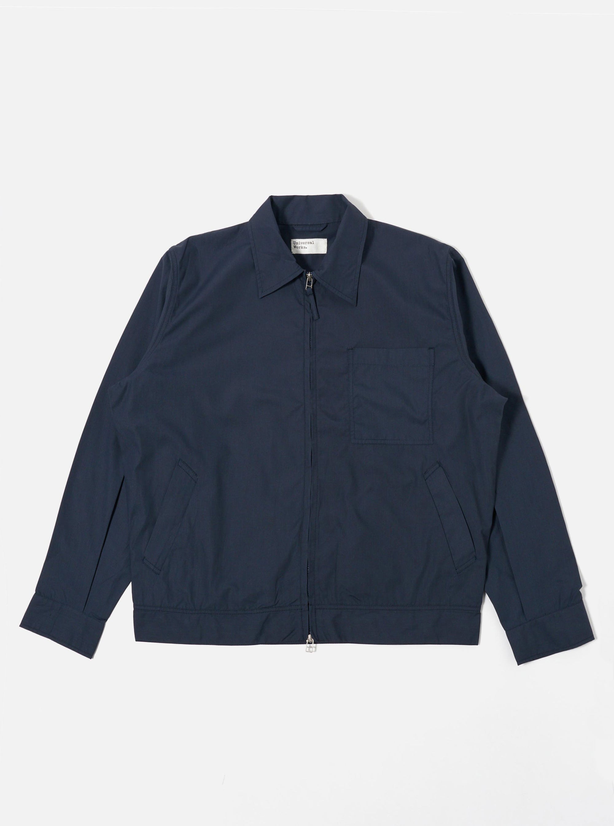 The Navy Recycled Polytech Rose Bowl Jacket is shown as a flat lay against a plain white background. The jacket features a central two-way zip-front closure, a slightly oversized collar, one large patch pocket on the left chest, and two welt pockets at the waist. The navy blue recycled polytech fabric has a smooth, technical appearance.
