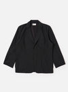 The Black Tropical Suiting Two Button Jacket is shown as a flat lay against a white background. The jacket features a relaxed fit with a long, wide notched lapel, two large lower patch pockets, and a single chest patch pocket. The two-button closure is visible at the center, and the fabric has a smooth, lightweight appearance.