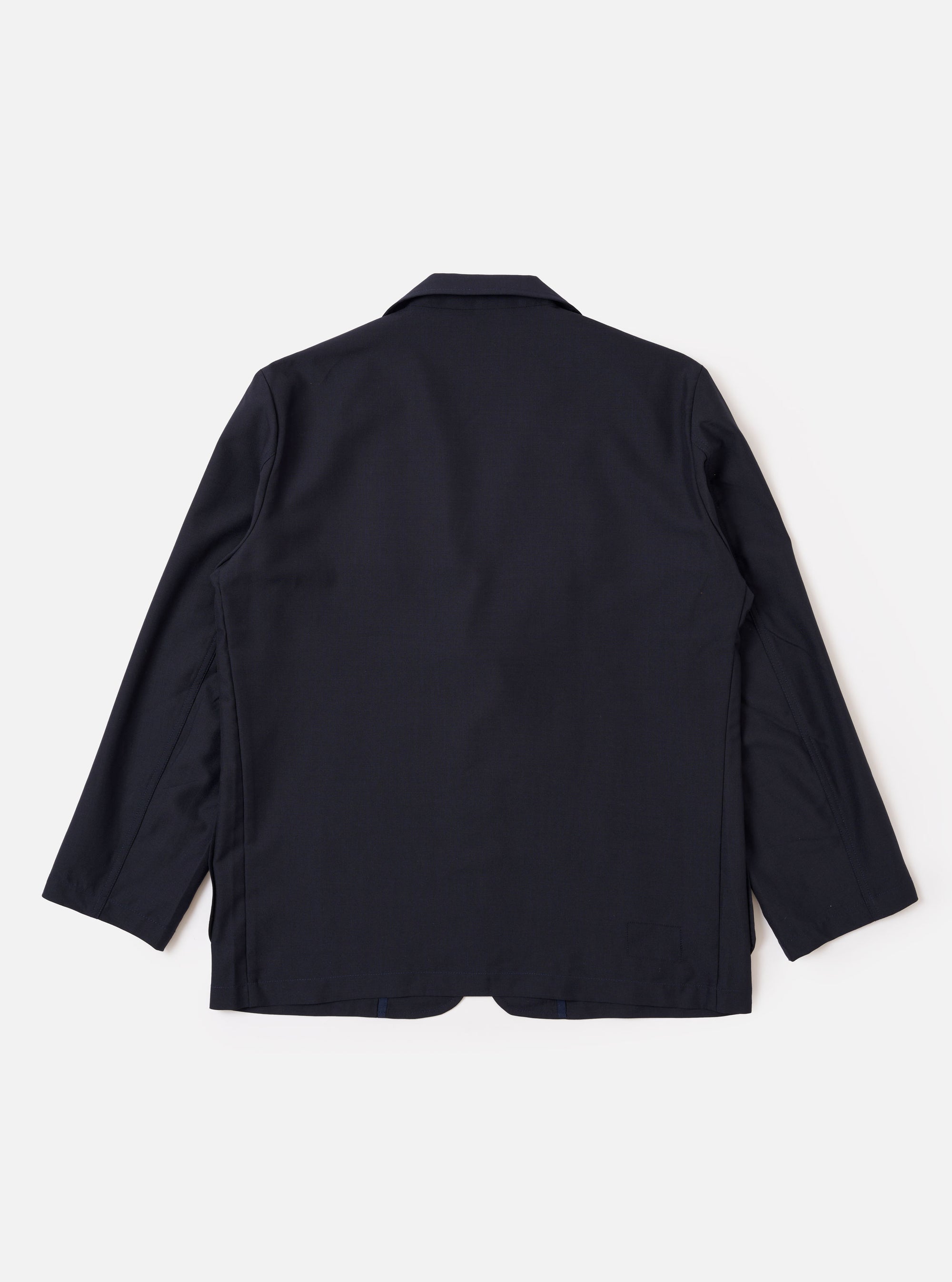 The Navy Tropical Suiting Two Button Jacket is shown from the back as a flat lay against a plain white background. The image highlights the clean, simple construction of the jacket's rear, the two-piece sleeve design, and the smooth texture of the navy tropical suiting fabric.