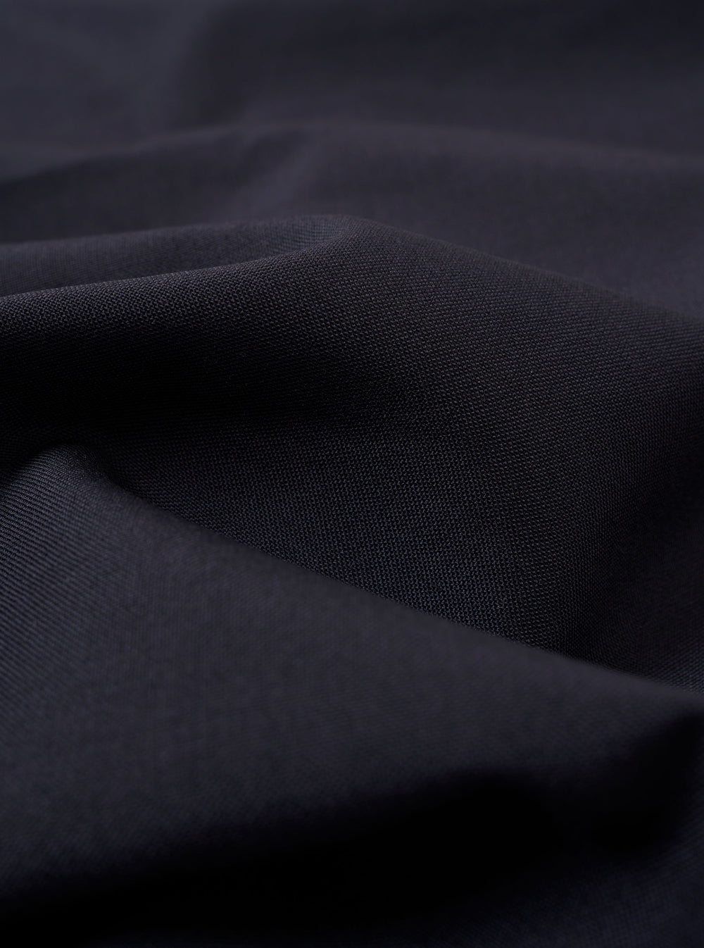 The Navy Tropical Suiting Two Button Jacket is displayed as a flat lay against a plain white background. The jacket features a two-button front closure, a notched lapel, two large patch pockets at the waist, and a single patch pocket at the chest. The navy wool-blend fabric has a smooth, lightweight appearance.