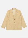 The Sand Organic Fine Cord Two Button Jacket is displayed as a flat lay against a plain white background. The jacket features a two-button front closure, a long and wide notched lapel, one chest patch pocket, and two larger patch pockets at the waist. The fine-wale organic cotton corduroy fabric has a visible vertical ribbed texture in a light sand color.
