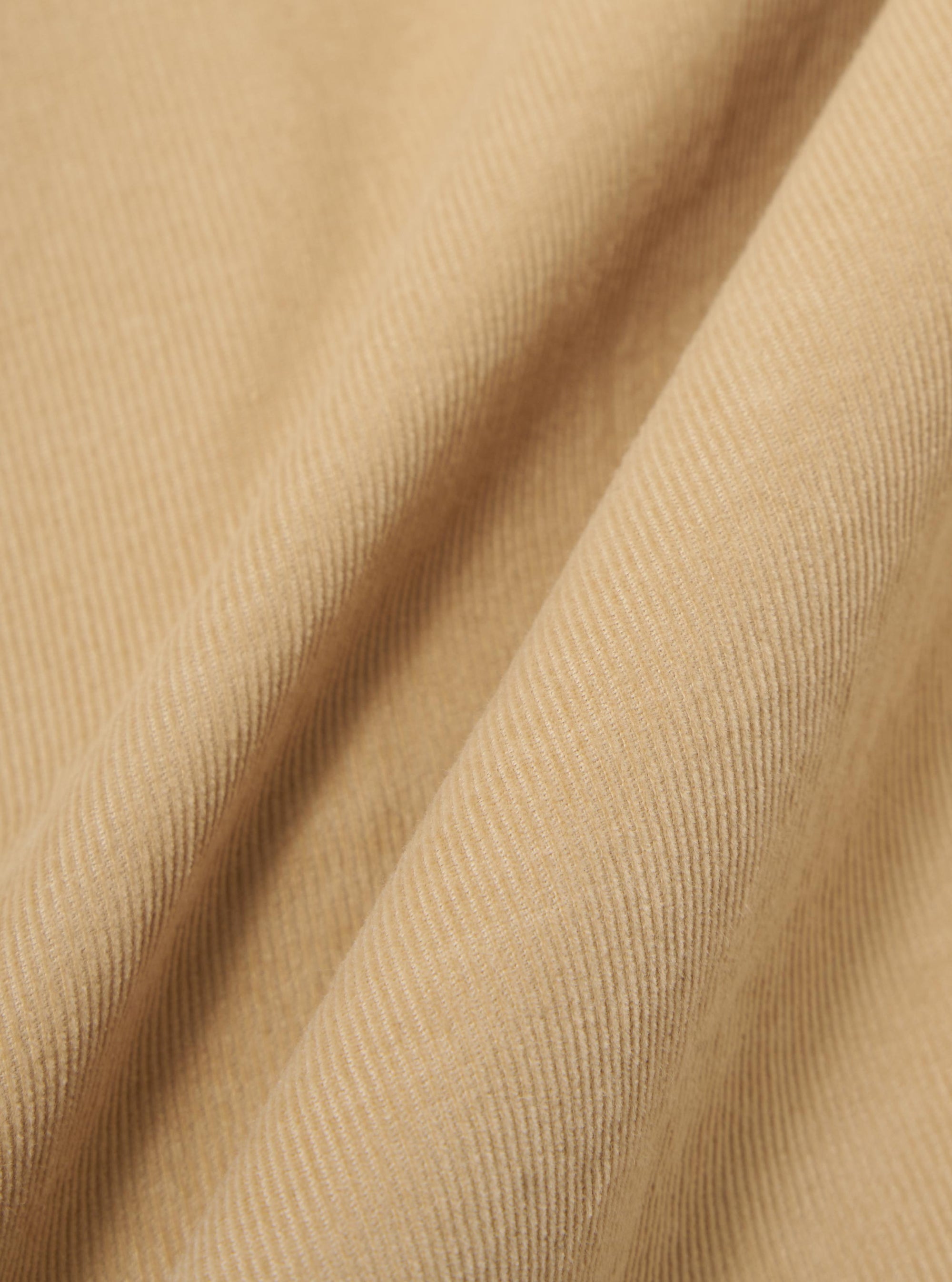 A close-up swatch image of the Sand Organic Fine Cord Two Button Jacket fabric displays a light sand-colored organic cotton with a distinct fine-wale corduroy texture. The vertical ridges of the corduroy material are clearly visible, filling the entire frame.