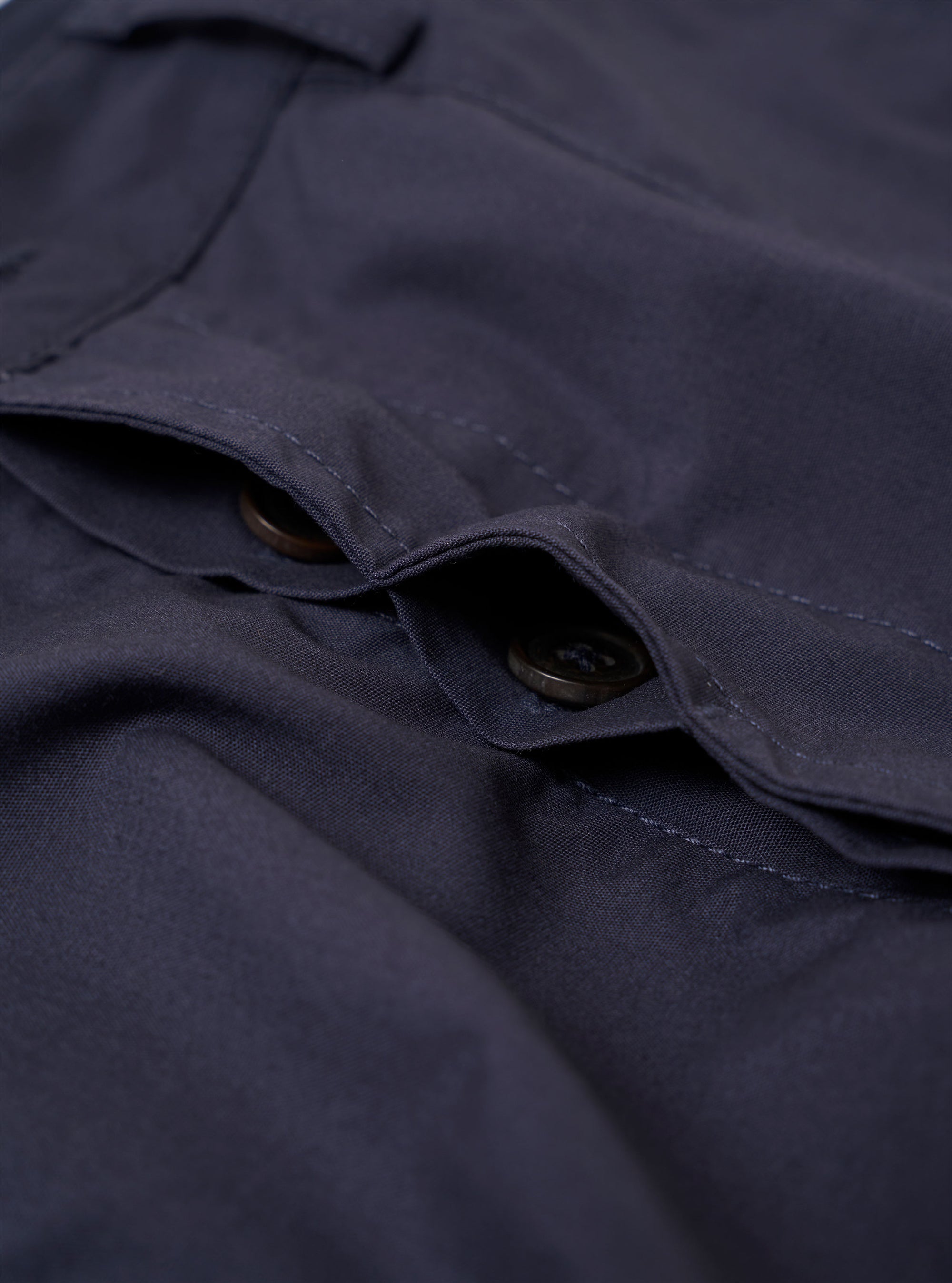 The Navy Peached Poplin Dutch Pant is shown as a flat lay against a white background. The trousers feature a wide-leg fit, an elasticated waistband with a drawstring, two large front patch pockets, and a single rear buttoned pocket. The peached cotton fabric has a soft, matte finish.