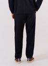 A model wears the Dark Navy Ospina Cotton Military Chino, shown from the waist down against a plain white background. The trousers feature a slim, straight fit and are constructed from a dark navy seersucker fabric with a distinct puckered texture. The image highlights the rear view of the garment, showcasing the fit and the pocket detailing.