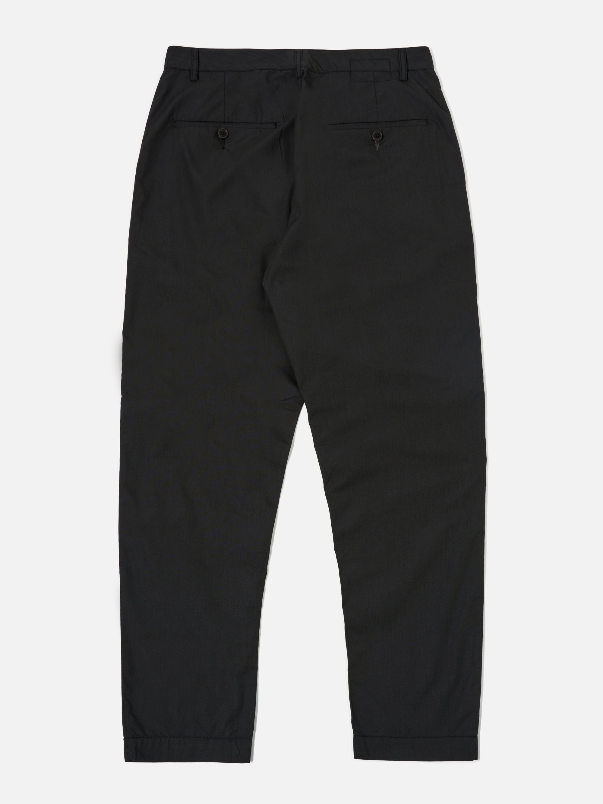 The Black Recycled Polytech Military Chino is shown from the back as a flat lay against a plain white background. The image highlights the two rear jetted buttoned pockets and the straight-cut design of the legs. The black recycled polytech fabric has a smooth, matte finish.