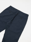 The Navy Recycled Polytech Military Chino is shown from a rear angle as a flat lay against a plain white background. The image highlights the two rear pockets, including one with a button-down flap, and the clean construction of the waistband.