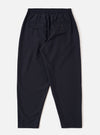 The Navy Tropical Suiting Pleated Track Pant is shown from the back as a flat lay against a plain white background. The image highlights the elasticated waistband and the two rear pockets, one of which features a buttoned flap. The navy wool-blend fabric has a smooth, clean finish.