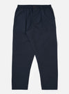 The Navy Recycled Polytech Pleated Track Pant is displayed as a flat lay against a plain white background. The trousers feature a loose, tapered fit with a single pleat at the front, an elasticated waistband with a tonal drawstring, and two side pockets. The dark navy recycled polytech fabric has a smooth, clean finish.