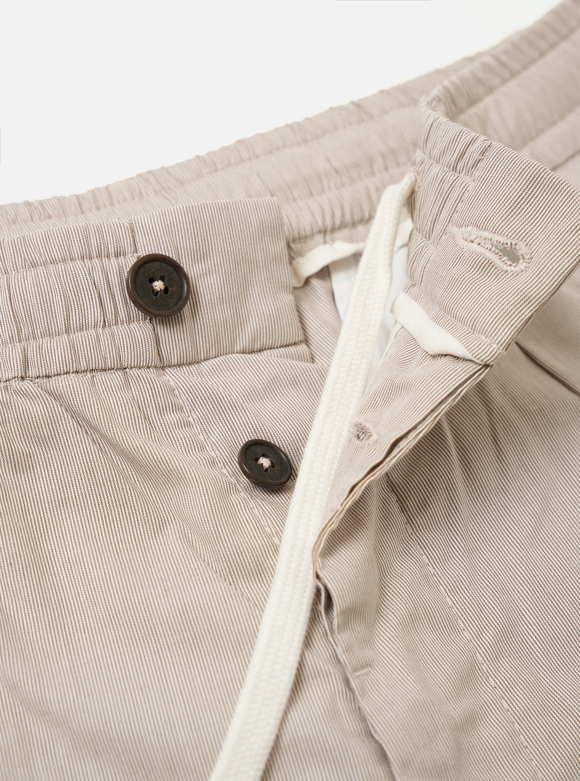 The Brown Kennedy Stripe Pleated Track Short is shown from the back as a flat lay against a white background. The image highlights the single rear button-down flap pocket and the vertical brown and white stripe pattern.