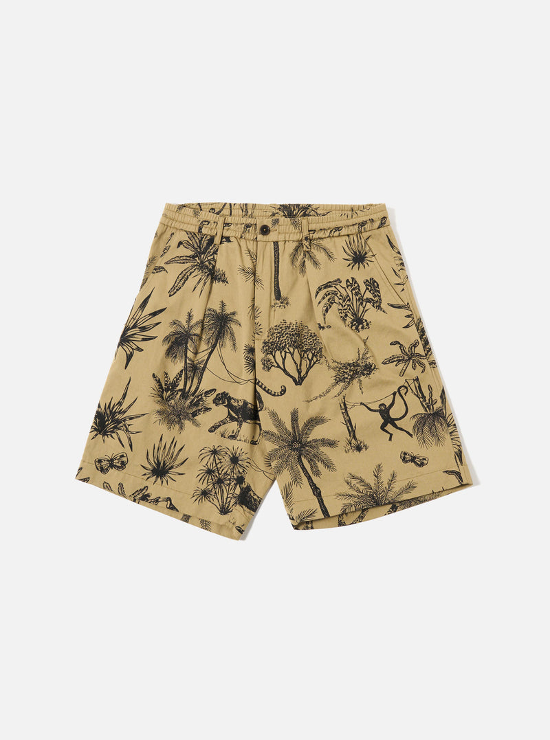 The Sand Jungle Toile Twill Pleated Track Short is shown as a flat lay against a plain white background. The shorts feature a prominent all-over dark jungle toile print on a sand-colored base, an elasticated waistband with a button fly, a single front pleat, and two side hand pockets. The fabric is a structured cotton twill.