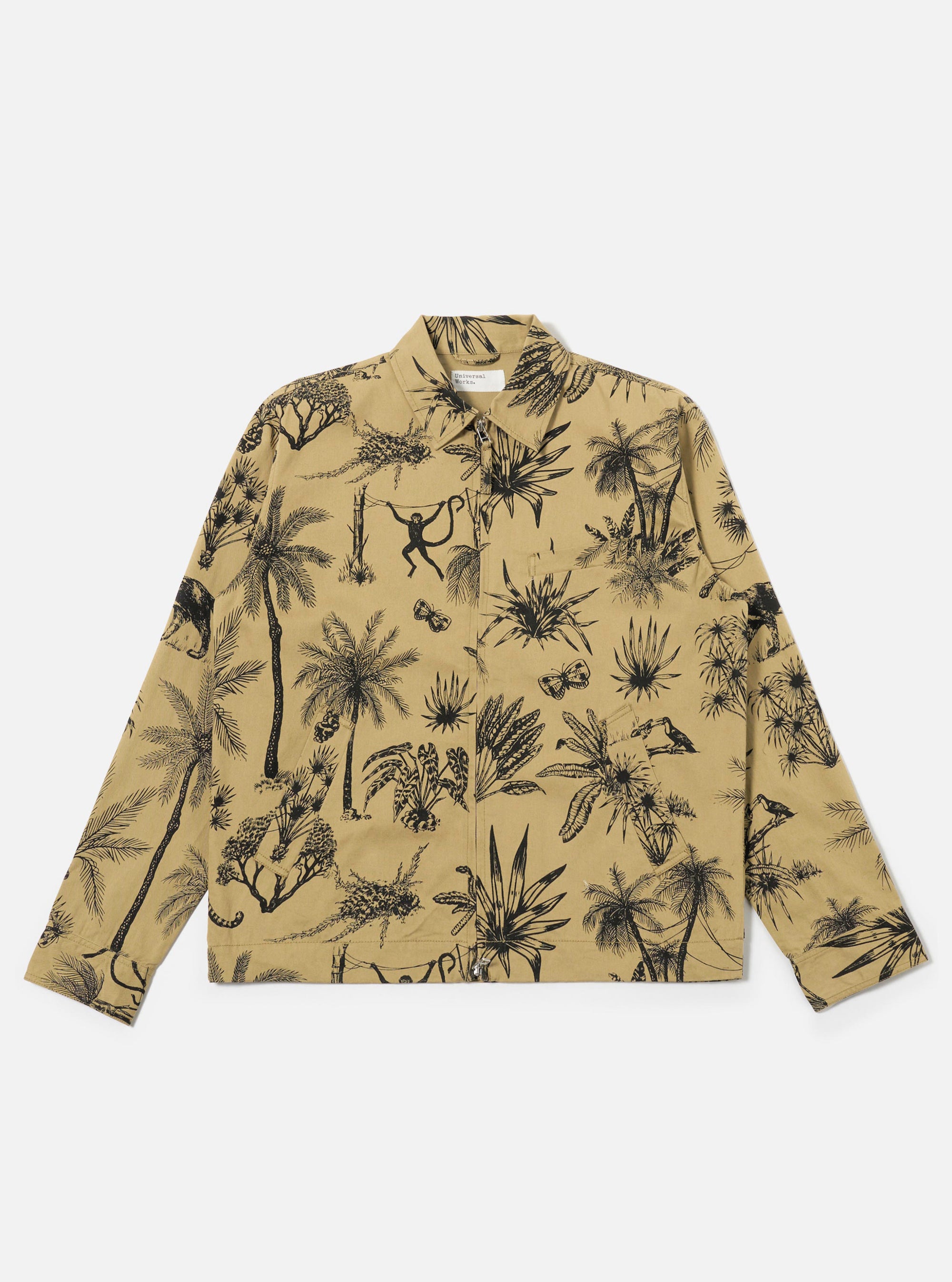 The Sand Jungle Toile Twill Windcheater Jacket is shown as a flat lay against a plain white background. The jacket features an all-over jungle toile print with dark illustrations of foliage and animals on a sand-colored base. It has a classic pointed collar, a central zip front, two slanted side pockets, and elasticated cuffs and hem.