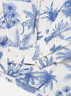 The White Jungle Toile Poplin Fatigue Shirt is shown in a detail view as a flat lay against a plain white background. The image focuses on the lower portion of the garment, highlighting the intricate dark botanical print on the white cotton poplin fabric and the clean stitching of the straight hem and side seam.
