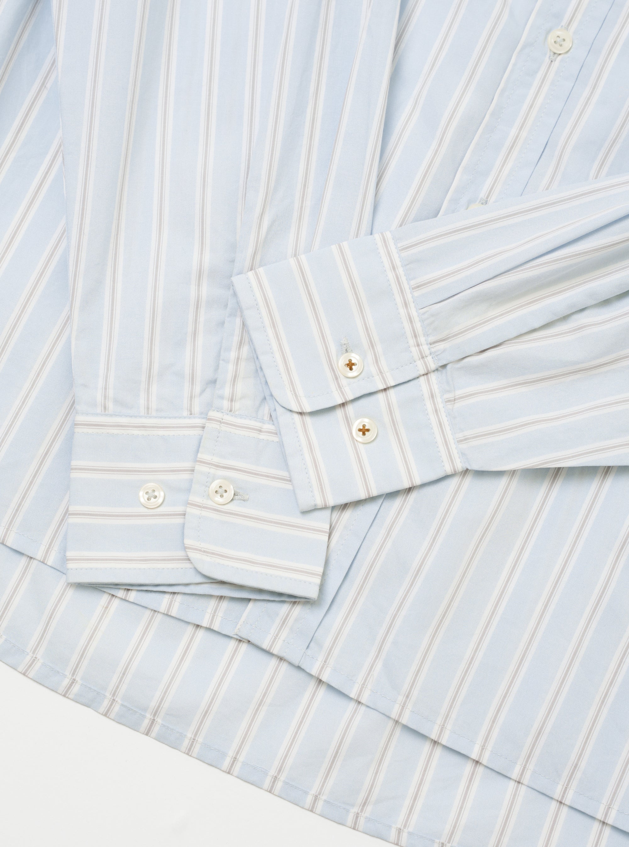 The Sky Urban Stripe Lazy Day Shirt is shown in a close-up detail shot as a flat lay against a plain white background. The image focuses on the upper portion of the shirt, highlighting the collar, the top buttons of the placket, and the fine blue and white vertical stripe pattern of the fabric.