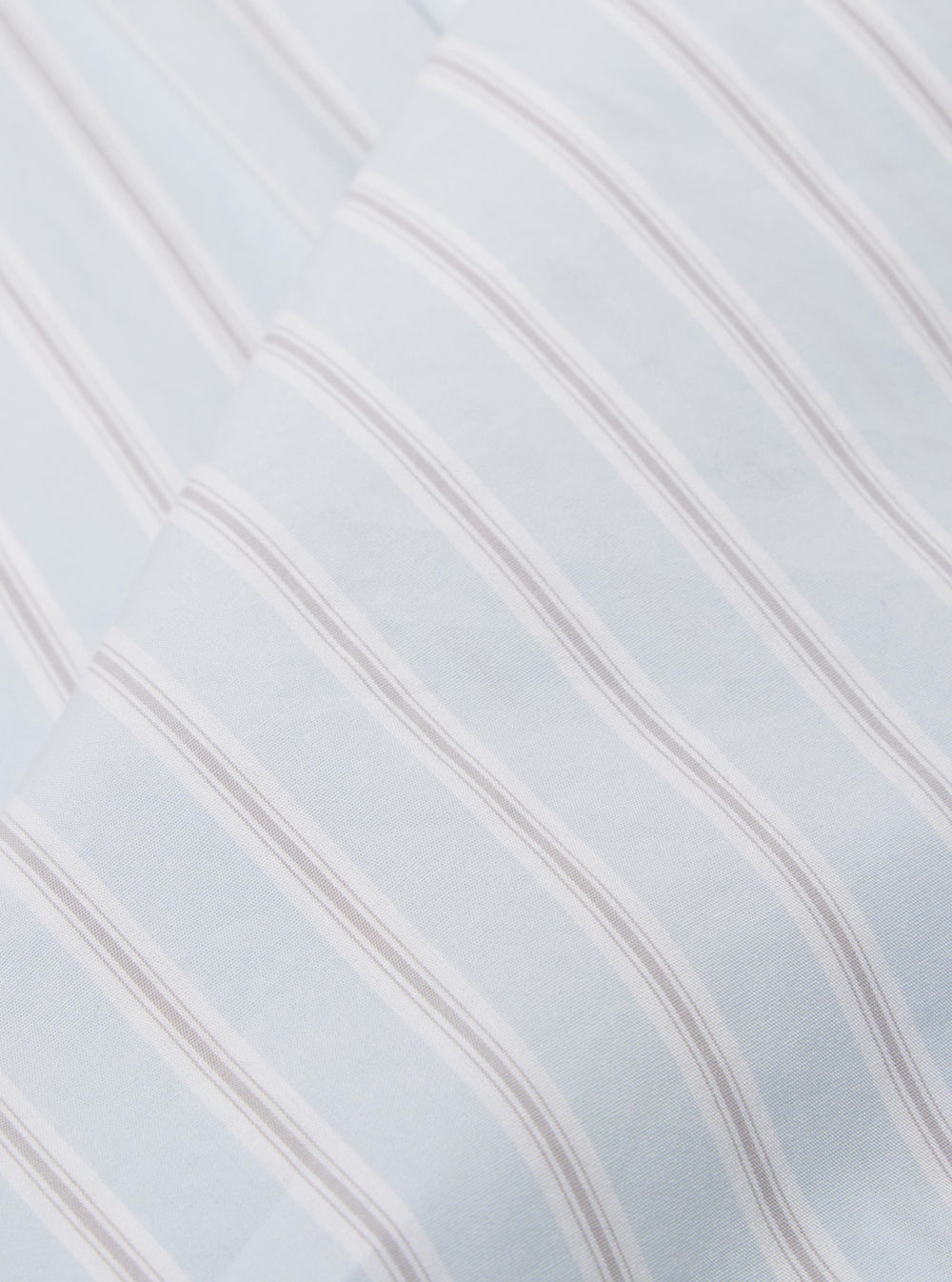 A close-up fabric swatch of the Sky Urban Stripe Lazy Day Shirt highlights the light blue and white vertical stripe pattern. The cotton fabric shows a fine weave and a smooth texture.