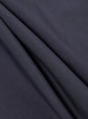 A close-up fabric swatch of the Navy Poplin Dwight Overshirt displays a deep navy blue color with a smooth, tight poplin weave. The image focuses entirely on the textile's surface and color.