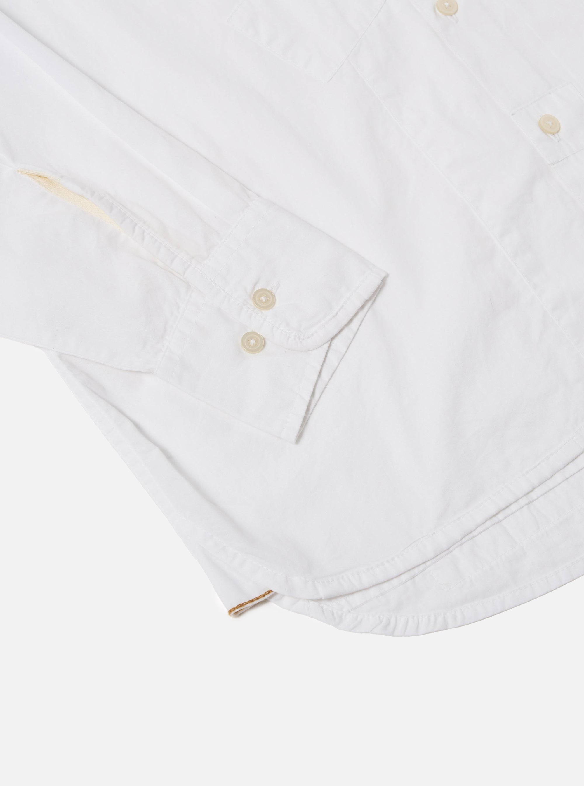 The White Poplin Patched Lazy Day Shirt is shown from a rear perspective on a model against a neutral, light-colored background. The image emphasizes the back yoke with a central box pleat and the relaxed drape of the white cotton poplin fabric. The model's head is not visible, focusing the view on the shirt's fit and construction from the shoulders to the waist.