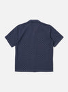 The Navy Dot Waffle Road Shirt is shown from the back as a flat lay against a plain white background. The shirt features a straight hem, short sleeves, and a structured one-piece collar. The fabric has a distinct rounded waffle texture throughout.