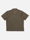 The Brown Fine Organic Cotton Sal Road Shirt is shown from the waist up on a model. The shirt features a camp collar, a single chest pocket, and a six-button front closure. The model is standing against a plain white background.