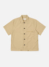 The Sand Recycled Polytech Z Tech Overshirt is shown as a flat lay against a white background. The overshirt features a one-piece collar, a central front closure, and a single reinforced vertical zip pocket on the left chest. The sand-colored fabric has a smooth, technical finish, and the garment is designed with a boxy fit and a straight hem.