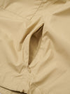 The Sand Recycled Polytech Z Tech Overshirt is shown in a detail view as a flat lay against a plain white background. The image highlights the smooth texture of the sand-colored recycled polytech fabric and the construction of the vertical zip chest pocket.
