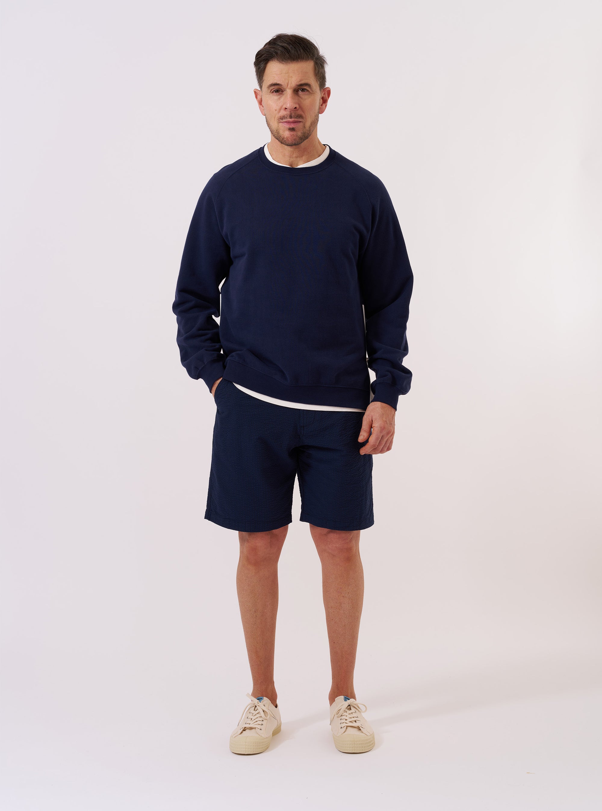 The Navy Brush Back Sweat Billy Sweat is shown as a flat lay against a plain white background. The sweatshirt features a classic crew neckline, ribbed cuffs, and a ribbed hem. The long sleeves are laid out to the sides, and the garment has a relaxed fit.