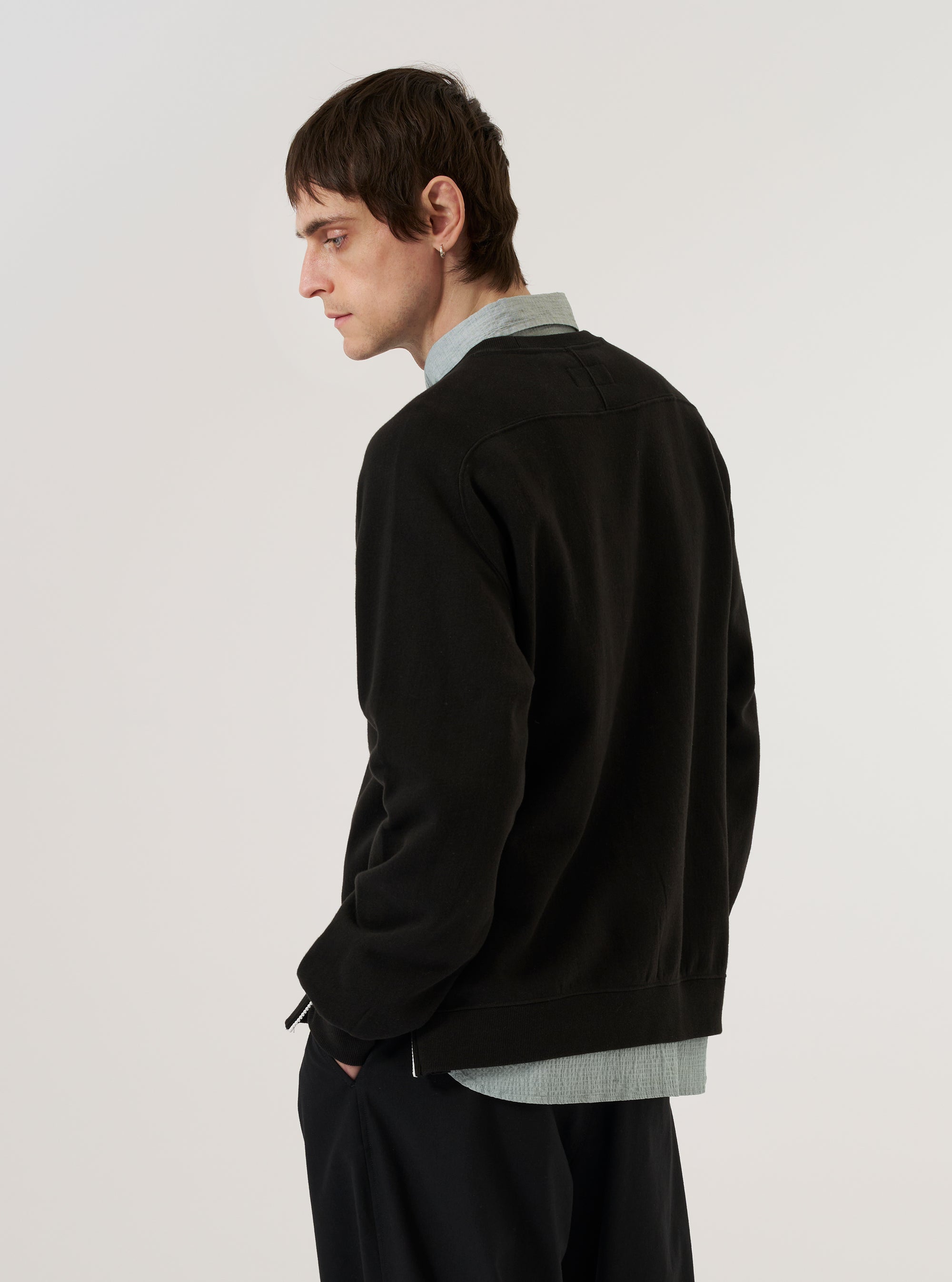 A model wears the Black Brush Back Sweat Billy Sweat, shown from the back against a plain white background. The sweatshirt features a relaxed fit, a classic crew neckline, and ribbed cuffs and hem. The black cotton fabric has a soft, matte finish.