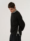 A model wears the Black Brush Back Sweat Billy Sweat, shown from a side profile against a plain white background. The sweatshirt features a crew neckline, ribbed cuffs, and a ribbed hem. The garment is made from a solid black brush-back cotton fabric with a smooth finish.