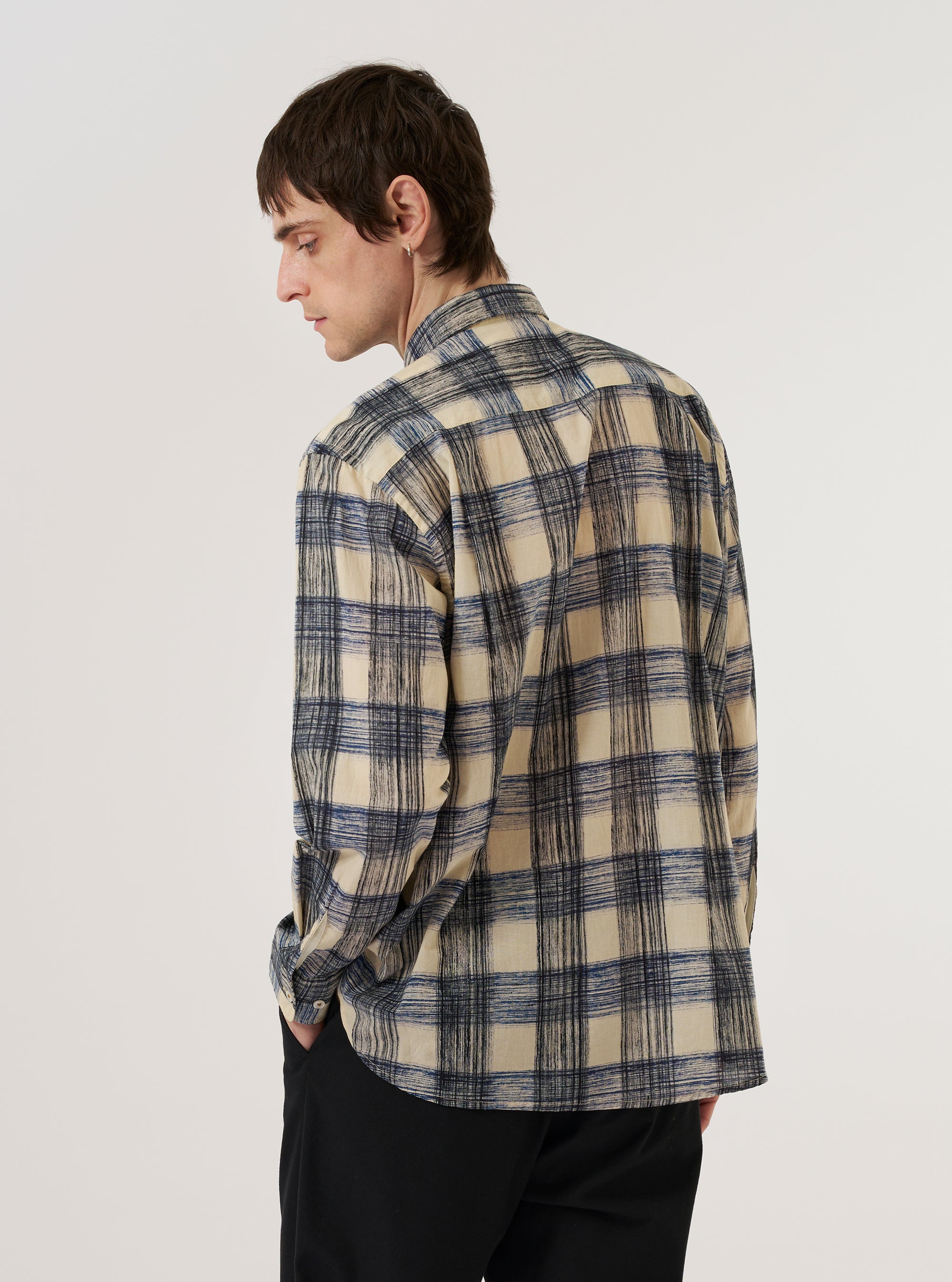A model is wearing the Navy Window Panes Square Pocket Shirt against a plain white background. The shirt features a dark navy base with a large-scale white windowpane check pattern, a classic button-down front, and a prominent square patch pocket on the left chest. The model is shown from the waist up, wearing the shirt with the top button open for a relaxed look.