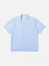 The Sky Fil A Fil Camp Shirt is shown as a flat lay against a white background. The short-sleeve shirt features a relaxed camp collar, a central six-button closure, and a single patch pocket on the left chest. The light blue cotton fabric has a fine, multi-tonal fil-a-fil weave.