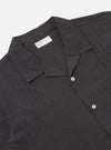 The Black Tech Cotton S/S Dwight Overshirt is shown from the back as a flat lay against a plain white background. The image highlights the short-sleeved, straight-hemmed construction of the garment and the smooth, crisp texture of the black tech cotton fabric.
