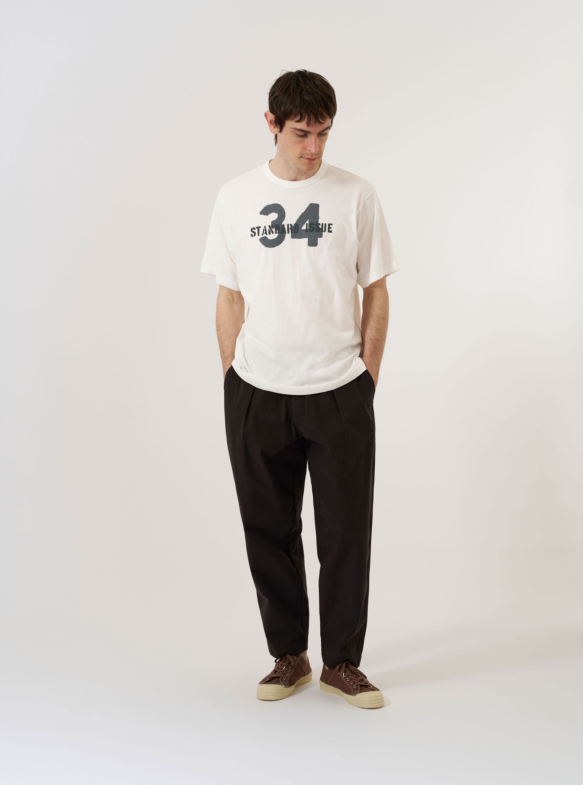 The Ecru Single Jersey 34 Printed Core Tee is shown as a flat lay against a plain white background. The short-sleeve t-shirt features a crew neckline with a self-bound trim and a printed graphic design on the front. The garment is made from an ecru-colored cotton jersey and includes a small woven branded label.