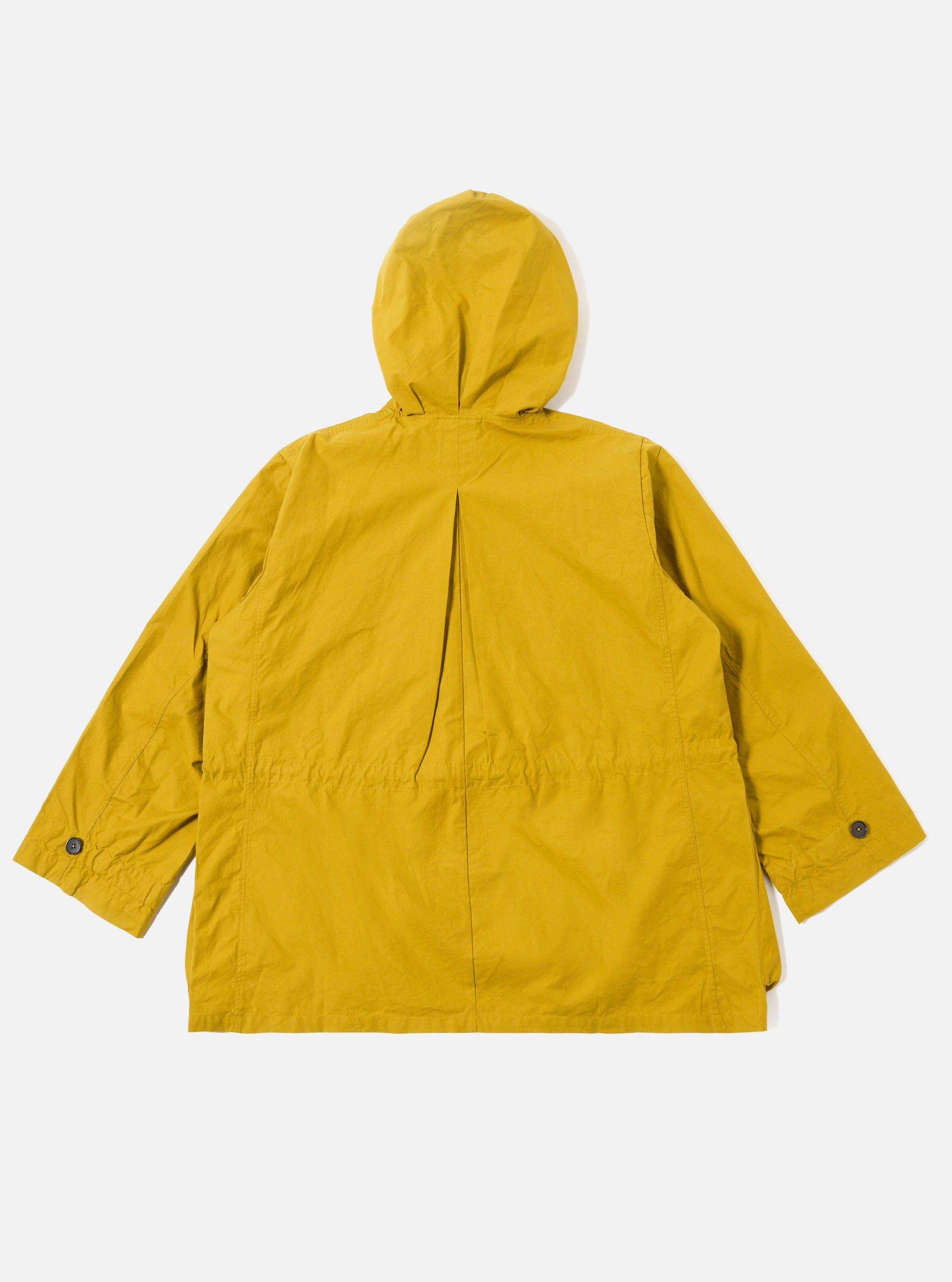 The Yellow British Wax Cotton Boston Parka is shown from the back as a flat lay against a plain white background. The image highlights the parka's matte yellow waxed cotton fabric, featuring a large adjustable hood and a prominent inverted box pleat at the center back. The garment has a straight hem and two-piece sleeves.