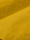 A close-up fabric swatch of the Yellow British Wax Cotton Boston Parka is shown, highlighting the vibrant yellow color and the smooth, dry texture of the British wax cotton material.