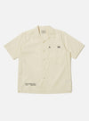 The A. SOCIETY x Universal Works Ecru Broadcloth Camp Shirt is laid flat on a white background. The shirt is a light cream color with short sleeves and a button-up front.